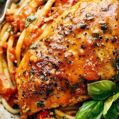 Garlic Basil Chicken in a bowl with spaghetti.