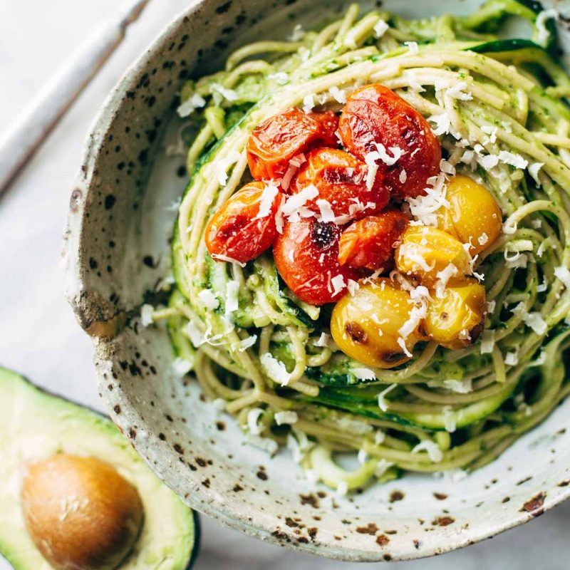 Zucchini spaghetti with tomato topping in a bowl.