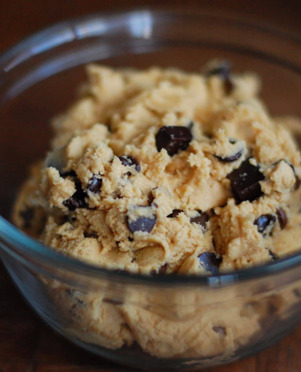 Chocolate chip cookie dough in a glass bowl.